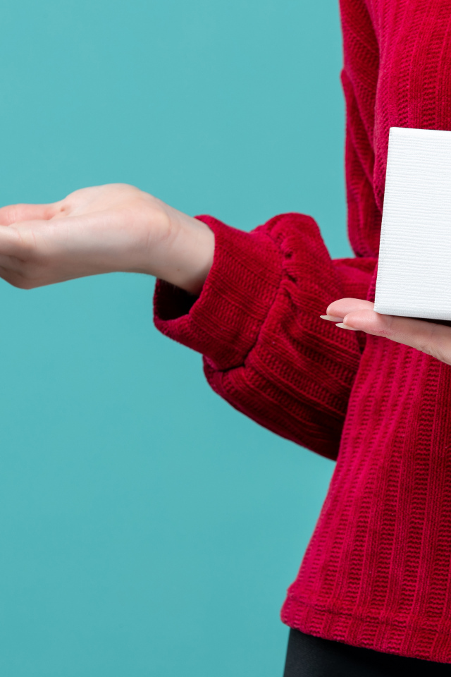 Коробка с сердцем в руке у девушки на голубом фоне