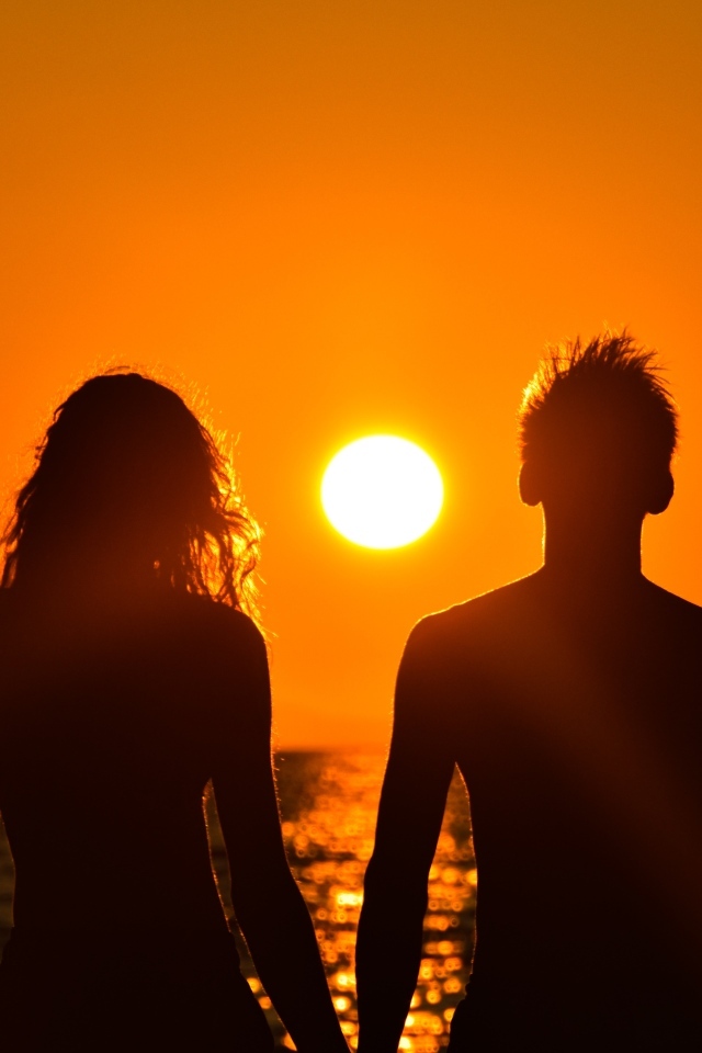 Влюбленная пара на фоне заката у моря