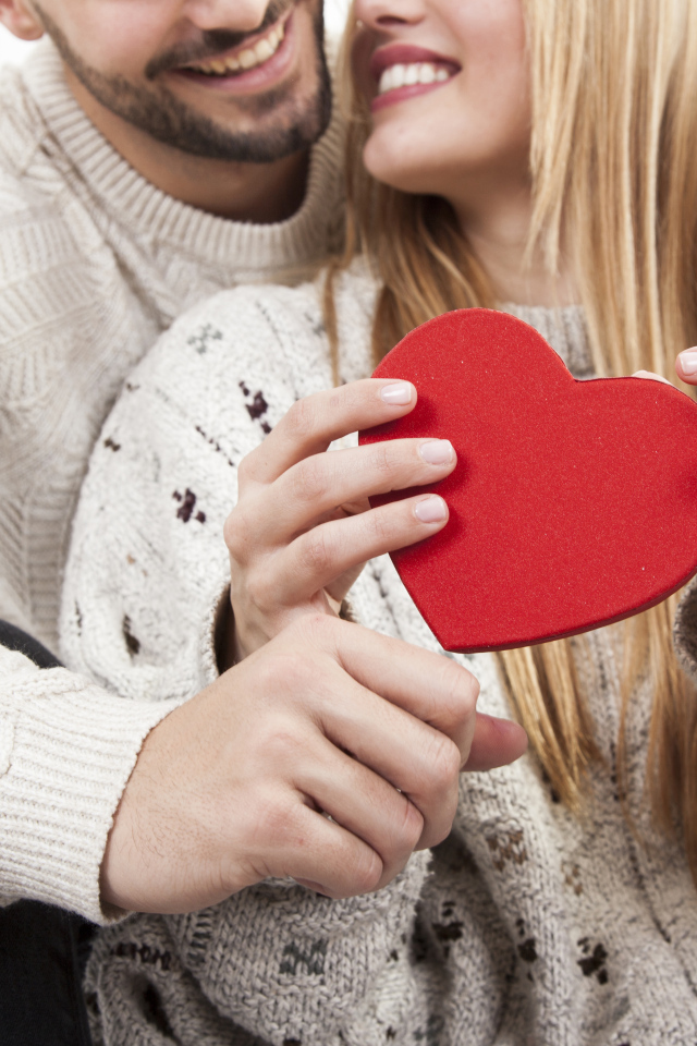 Влюбленная пара с красным сердцем в руках