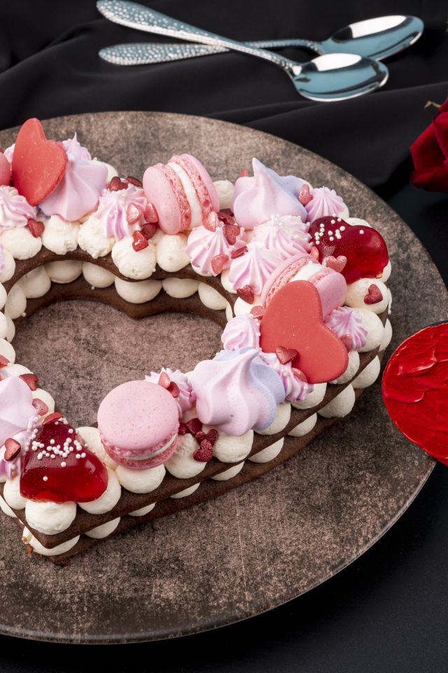 Десерт в форме сердца на столе с красной розой