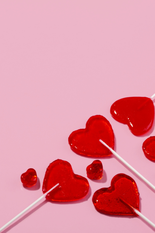 Леденцы в форме сердца на розовом фоне