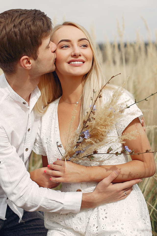 Поцелуй красивой пары на поле