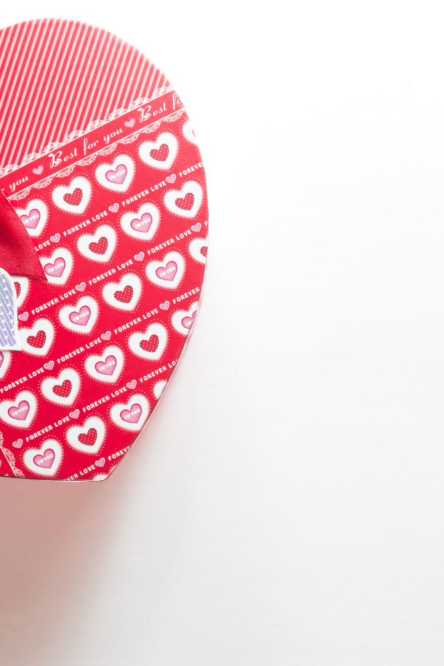 Большая подарочная коробка в форме сердца на белом фоне