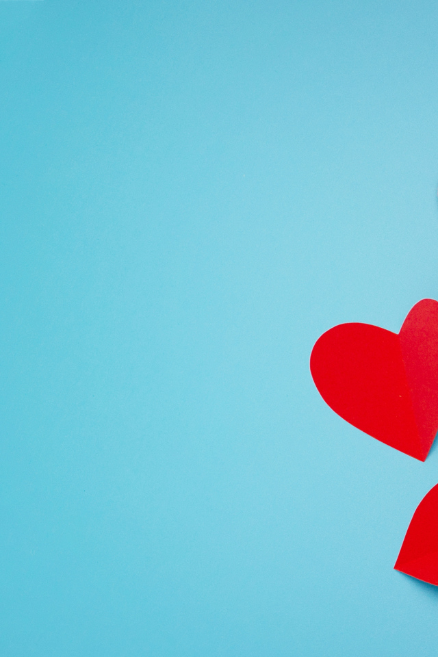 Много красных бумажных сердечек на голубом фоне