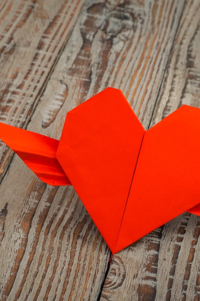 Бумажное красное сердце на деревянных досках