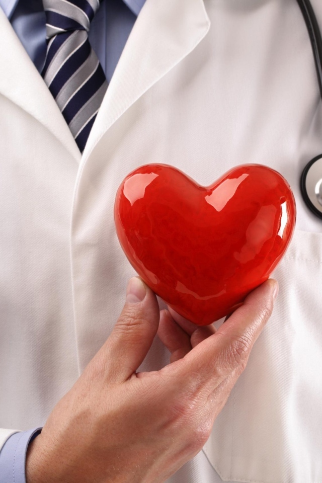 Красное сердце в руках доктора в белом халате
