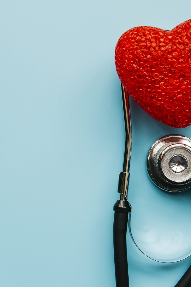 Красное сердце с стетоскопом на голубом фоне