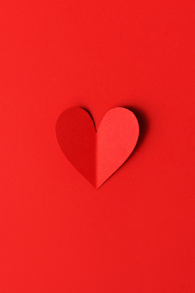 Маленькое бумажное сердце на красном фоне