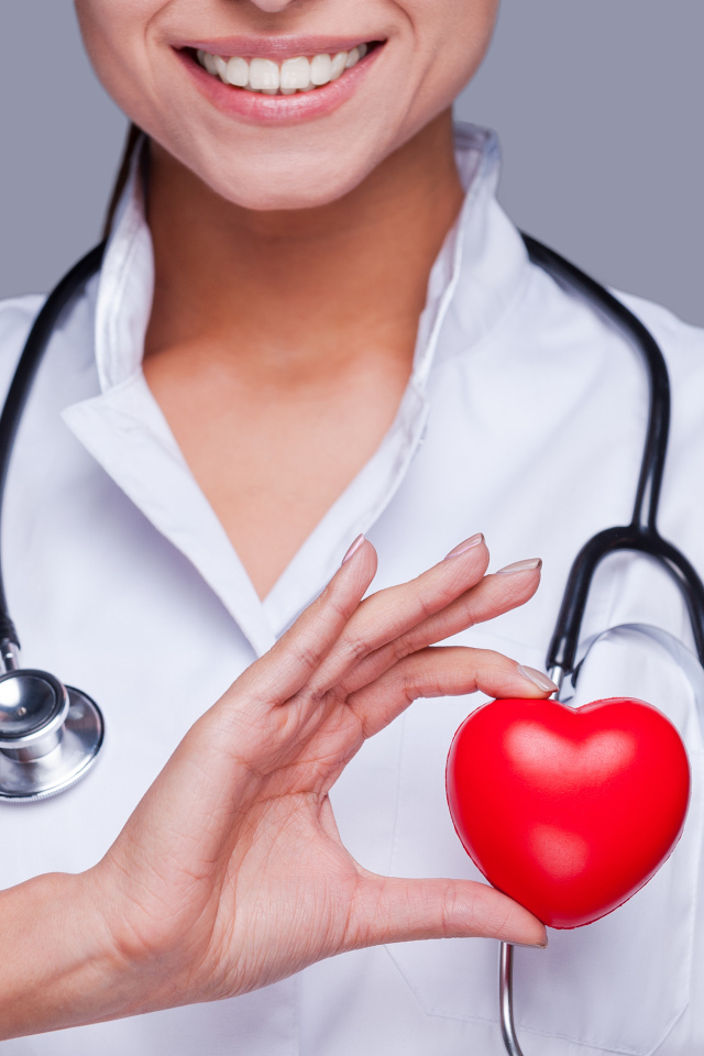 Улыбающаяся женщина врач с красным сердцем