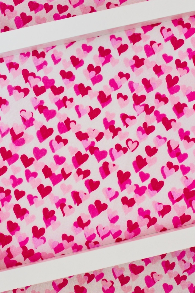 Белая рамка на ткани с маленькими сердечками