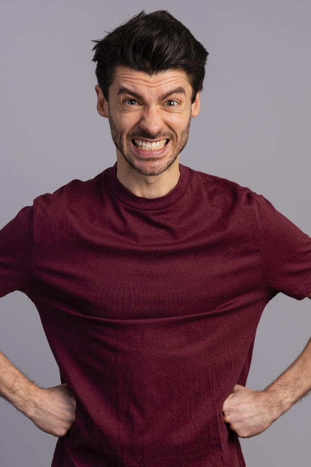 Злой мужчина на сером фоне