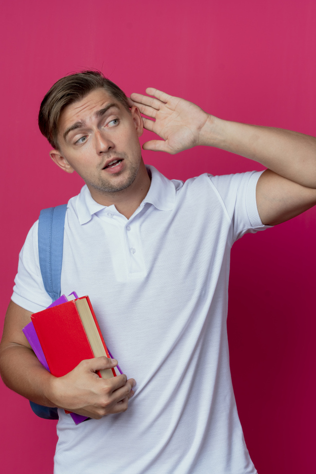 Парень с книгами в руке на красном фоне