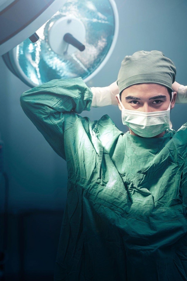 Мужчина врач в костюме в операционной