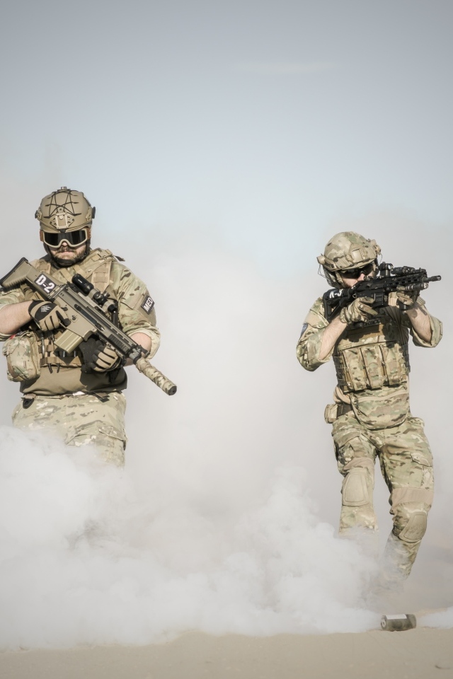 Мужчины солдаты с оружием в дыму