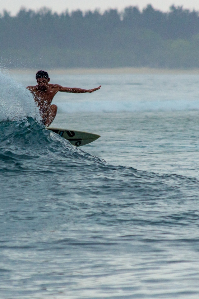 Мужчина серфингист ловит волну