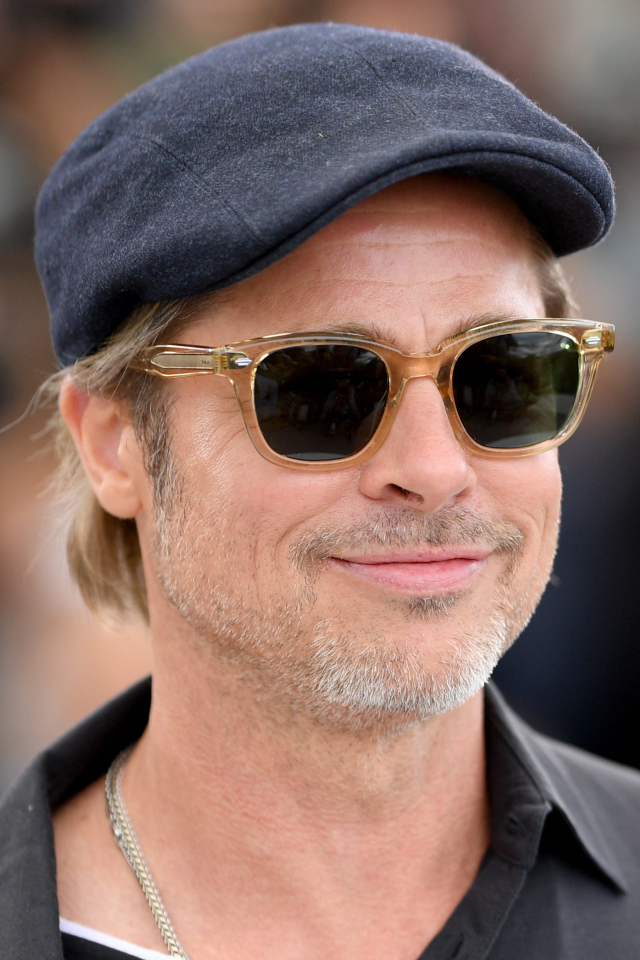 Актер Брэд Питт в кепке и очках