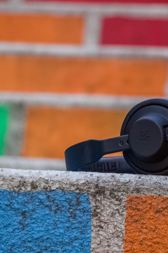 Черные наушники лежат на стене