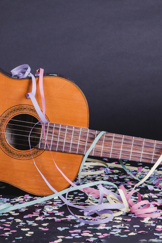 Гитара в конфетти у серой стены