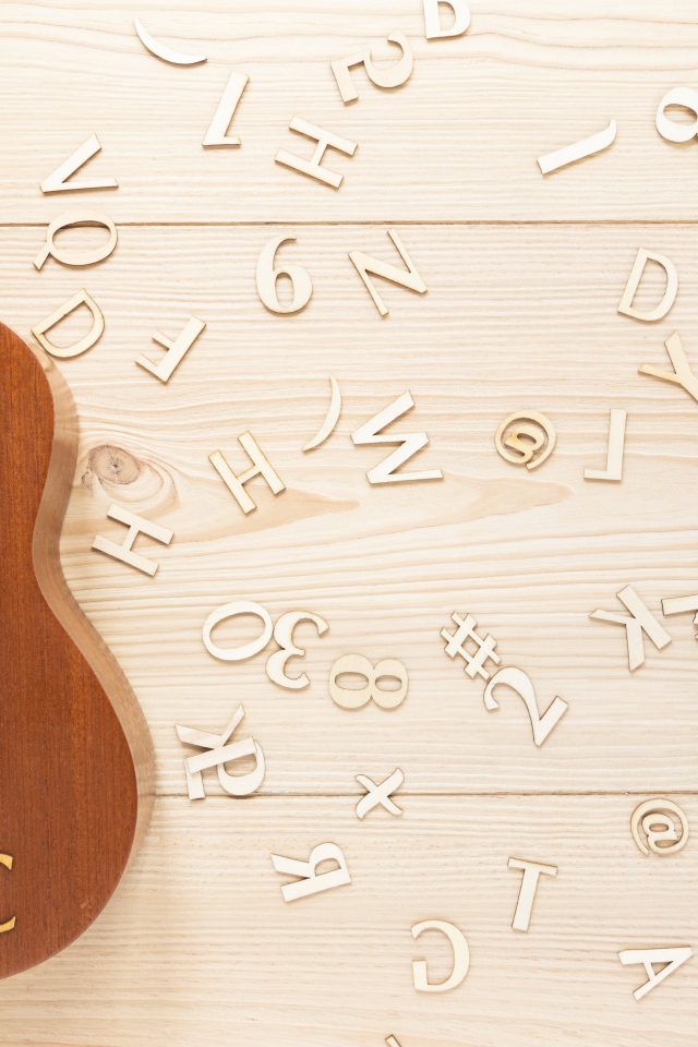 Гитара на столе с деревянными буквами