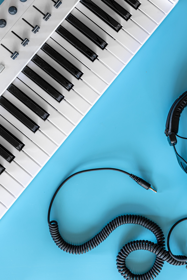 Наушники на голубом фоне с синтезатором