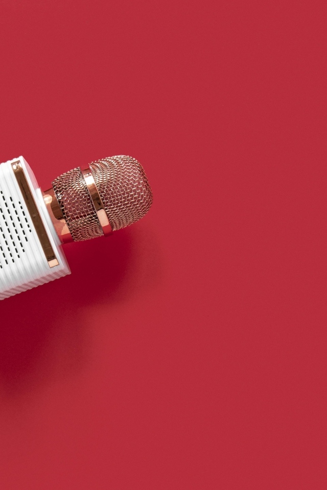 Радиомикрофон в руке на красном фоне