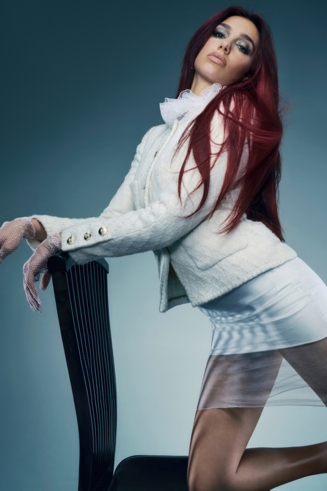 Рыжеволосая певица Дуа Липа в белом костюме у стула