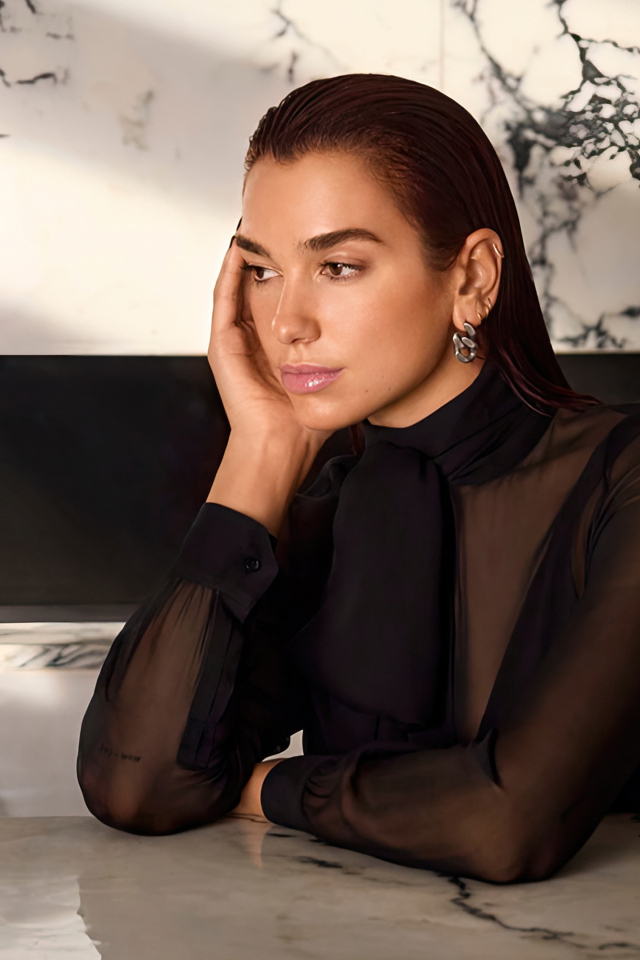 Грустная певица Дуа Липа сидит за столом