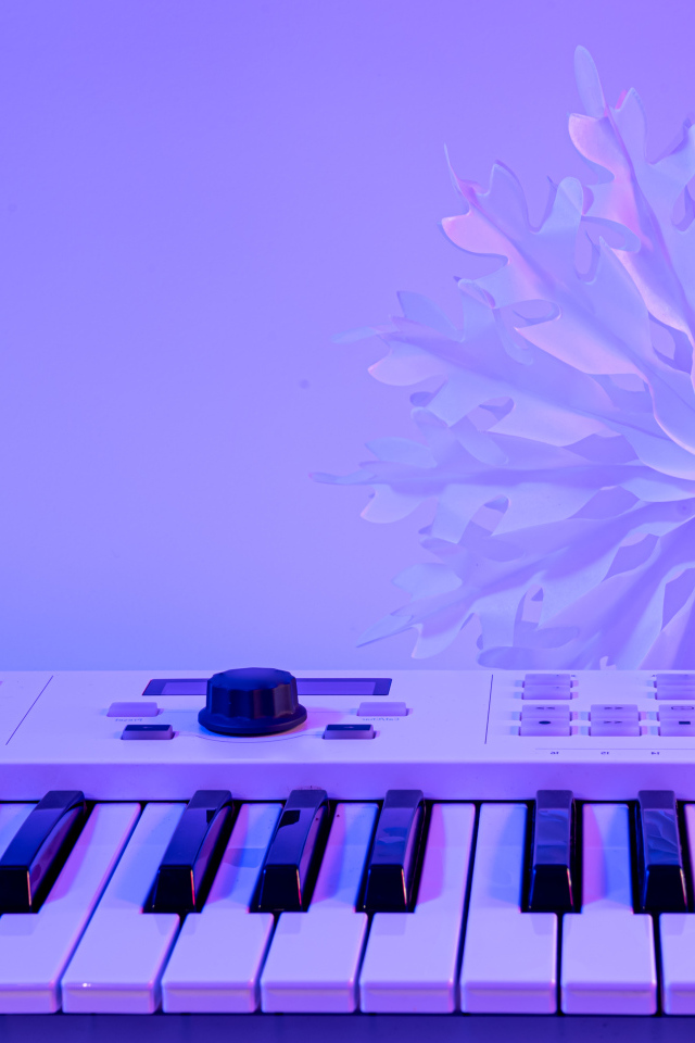 Синтезатор с бумажной снежинкой на фиолетовом фоне