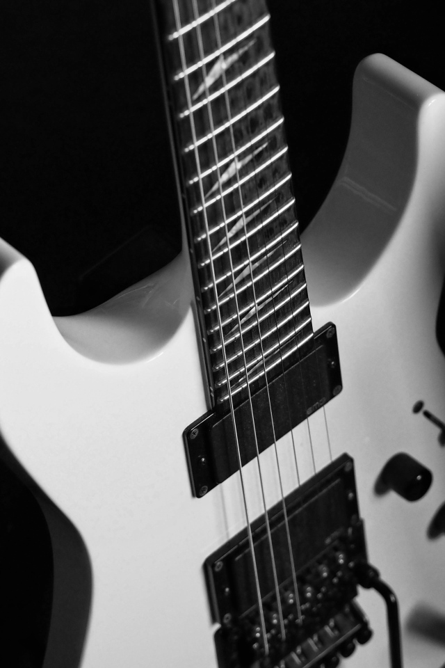 Белая электрогитара на черном фоне