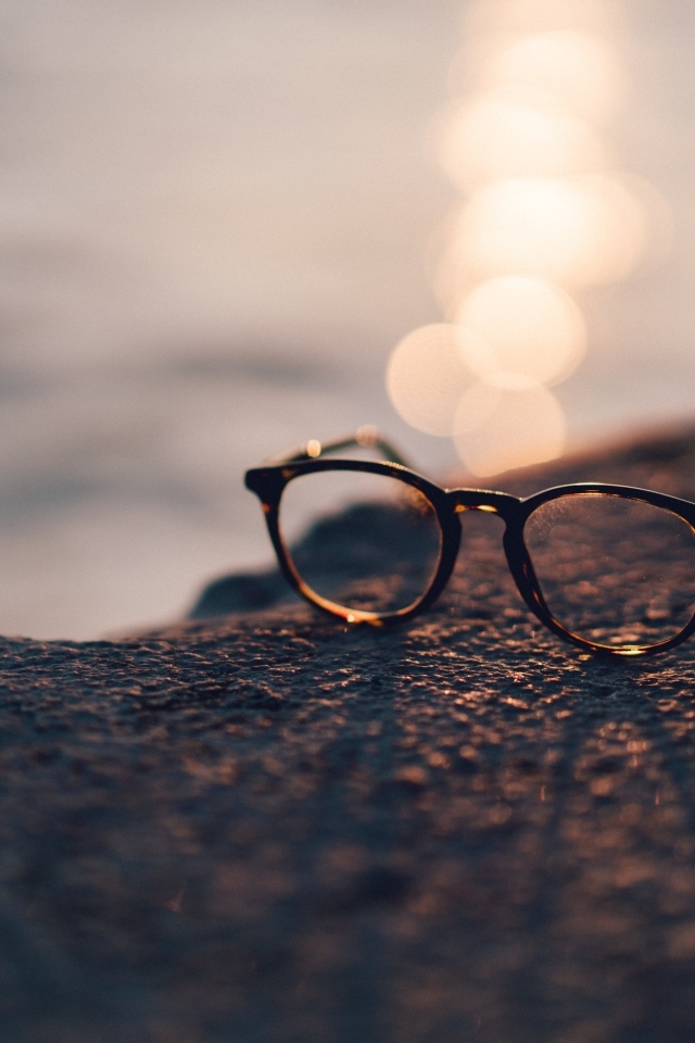 Очки лежат на камне в лучах солнца