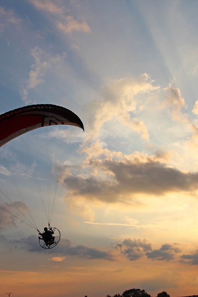 Параплан в небе на фоне солнца