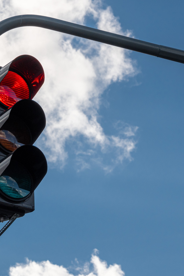 Красный свет светофора на фоне неба