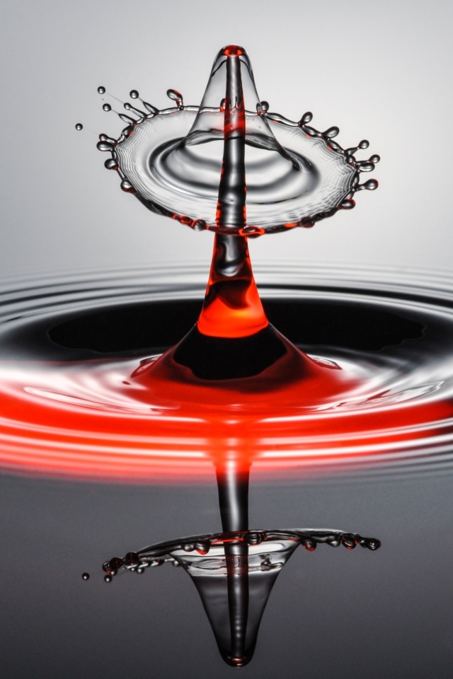 Брызги от капли воды на серой поверхности