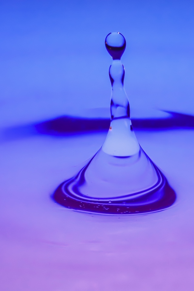 Брызги в воде на фиолетовом фоне