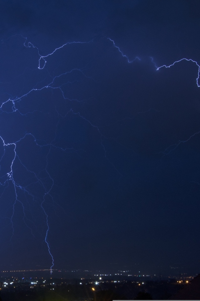 Белая яркая молния в небе над городом