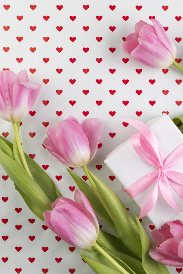 Букет розовых тюльпанов и подарок на фоне с сердечками