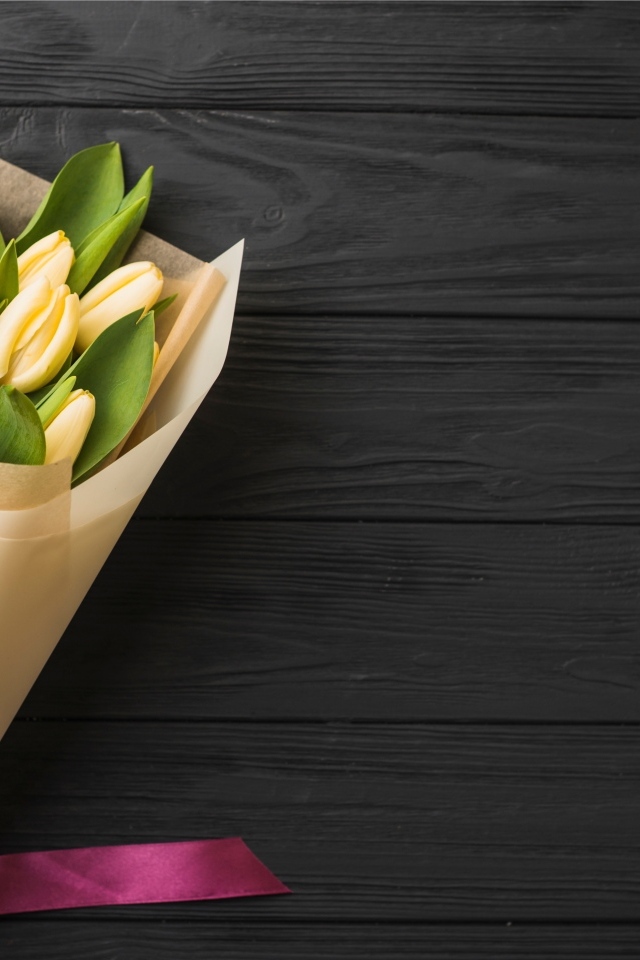 Букет желтых тюльпанов в бумажной упаковке с лентой