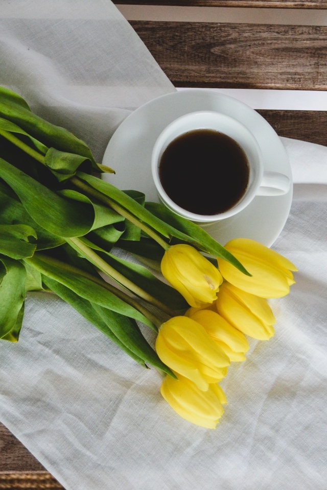 Букет желтых тюльпанов с чашкой кофе на лавке