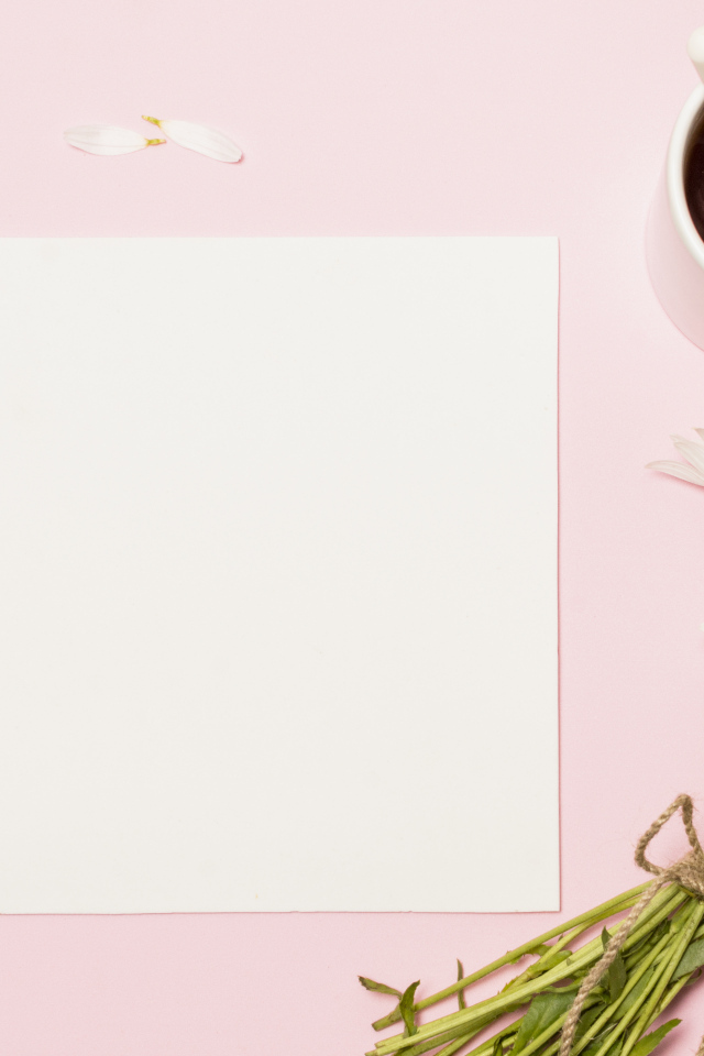 Розовый фон с ромашками, чашкой чая и белым листом бумаги, шаблон