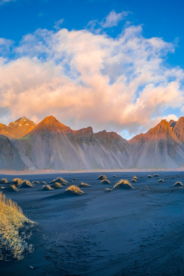 Облако в голубом небе над покрытой солнцем горой