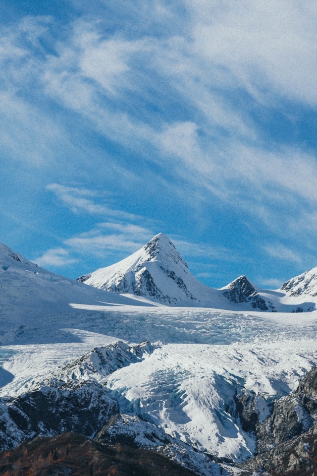 Высокие заснеженные горы под голубым ясным небом