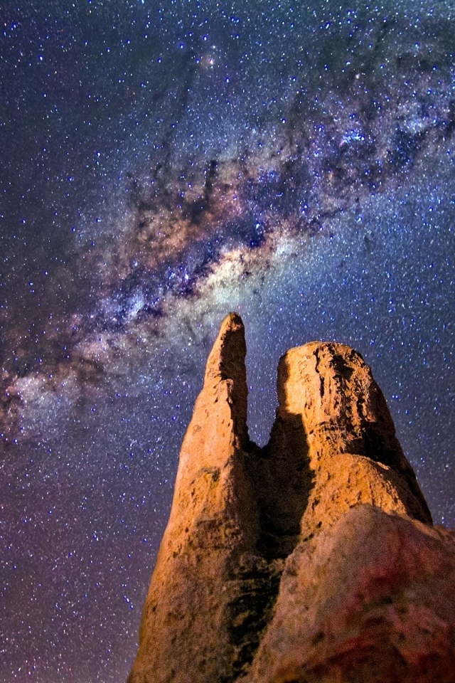 Млечный путь в звездном небе над острой  горной вершиной