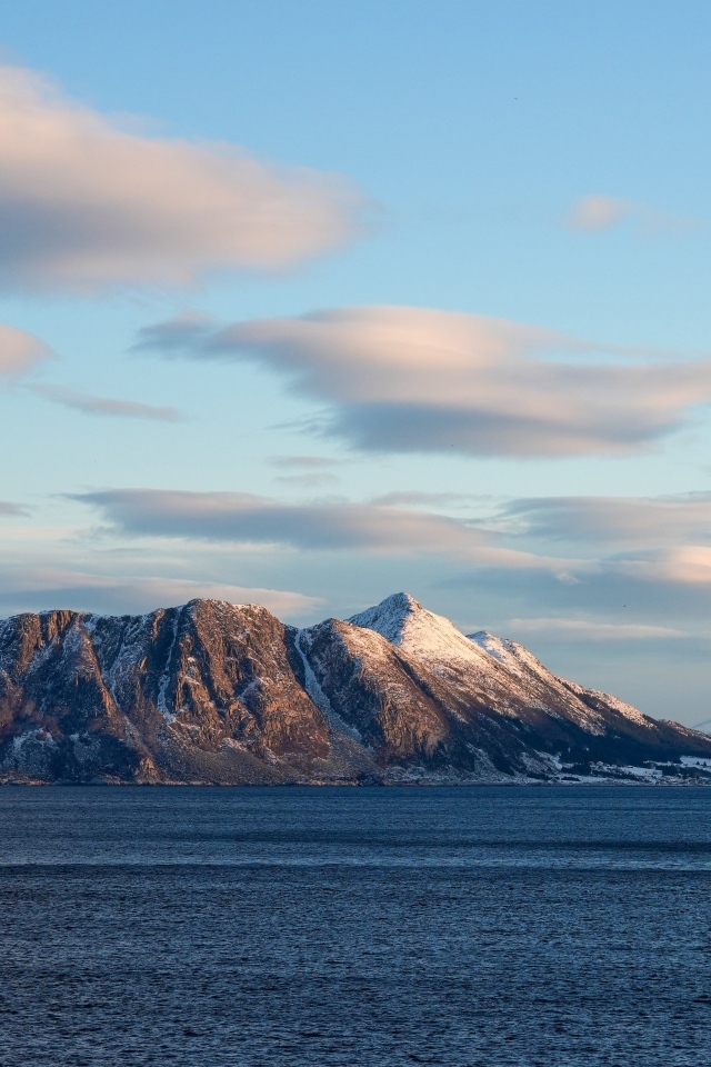 Скала в лучах солнца в море
