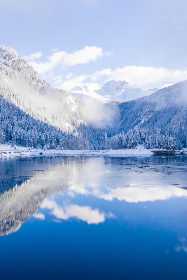 Покрытые снегом горы у покрытого льдом озера