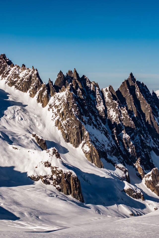 Солнце покрывает заснеженные горы