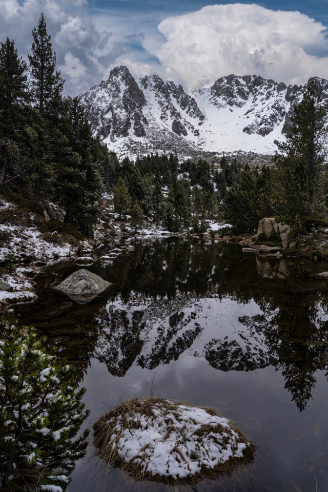 Холодная вода в озере с большими камнями на фоне гор
