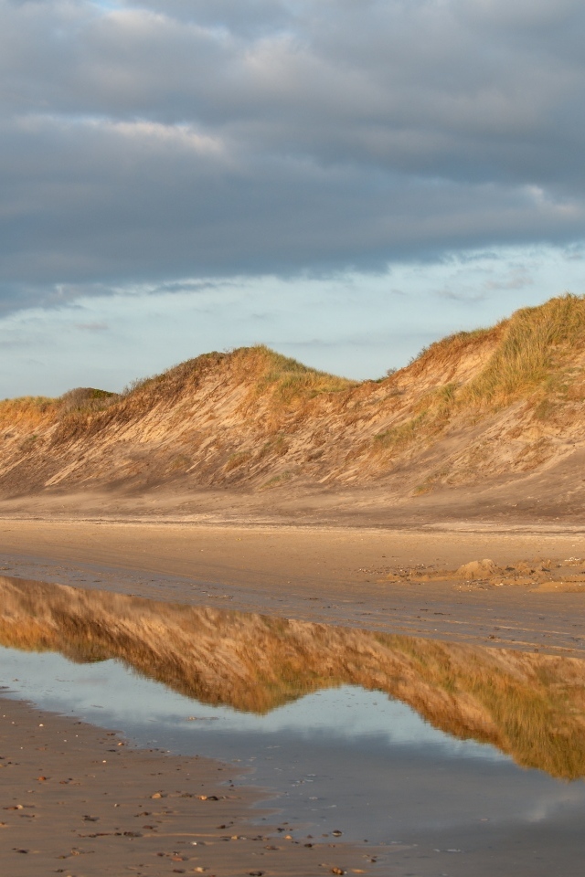 Холты отражаются в реке под грозовым небом