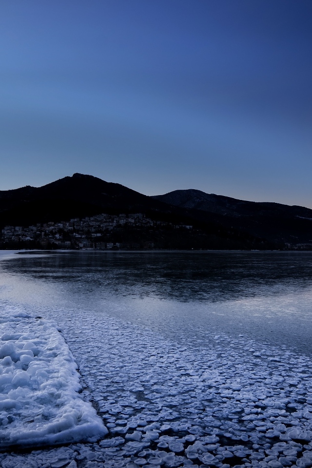 Заледеневшая вода в горном озере в сумерках