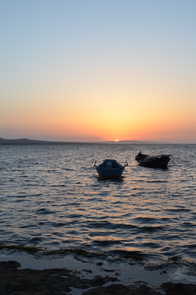 Лодки на морском побережье на закате