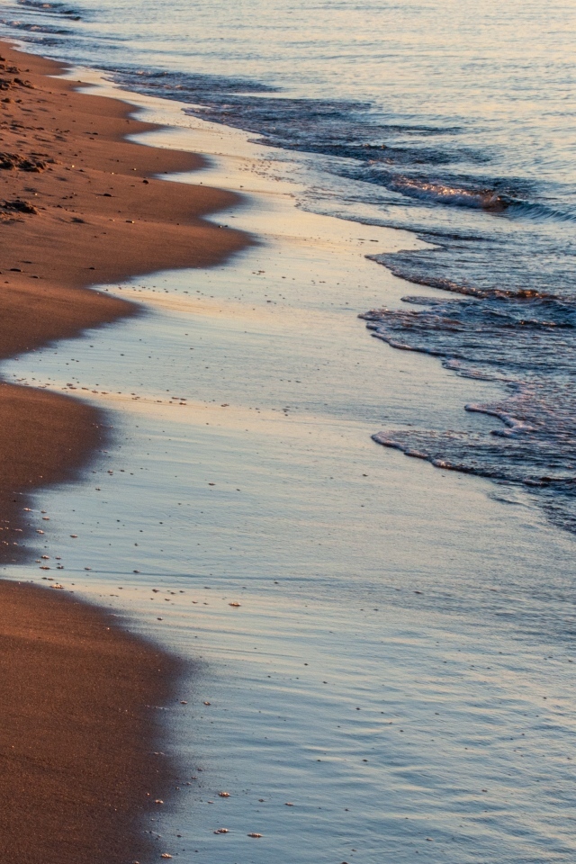 Спокойное море на морском песке на рассвете